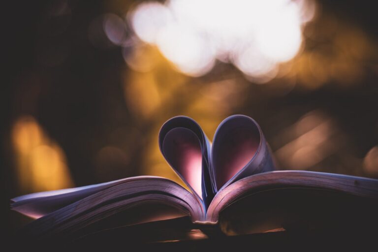 Open book with heart-shaped pages, illuminated by warm, bokeh lighting, perfect for romantic themes.
