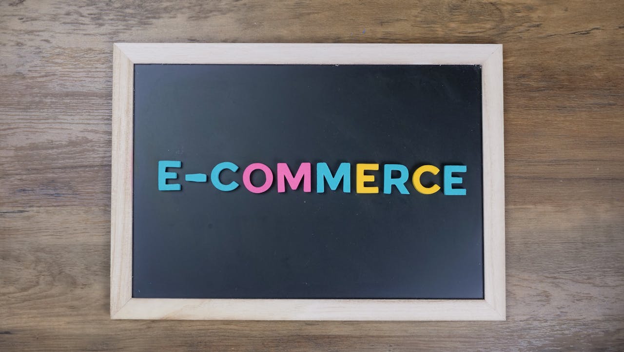 About Colorful letters spelling 'e-commerce' on a wooden framed blackboard.